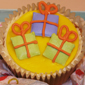 Cup cake with birthday presents iced onto cake top